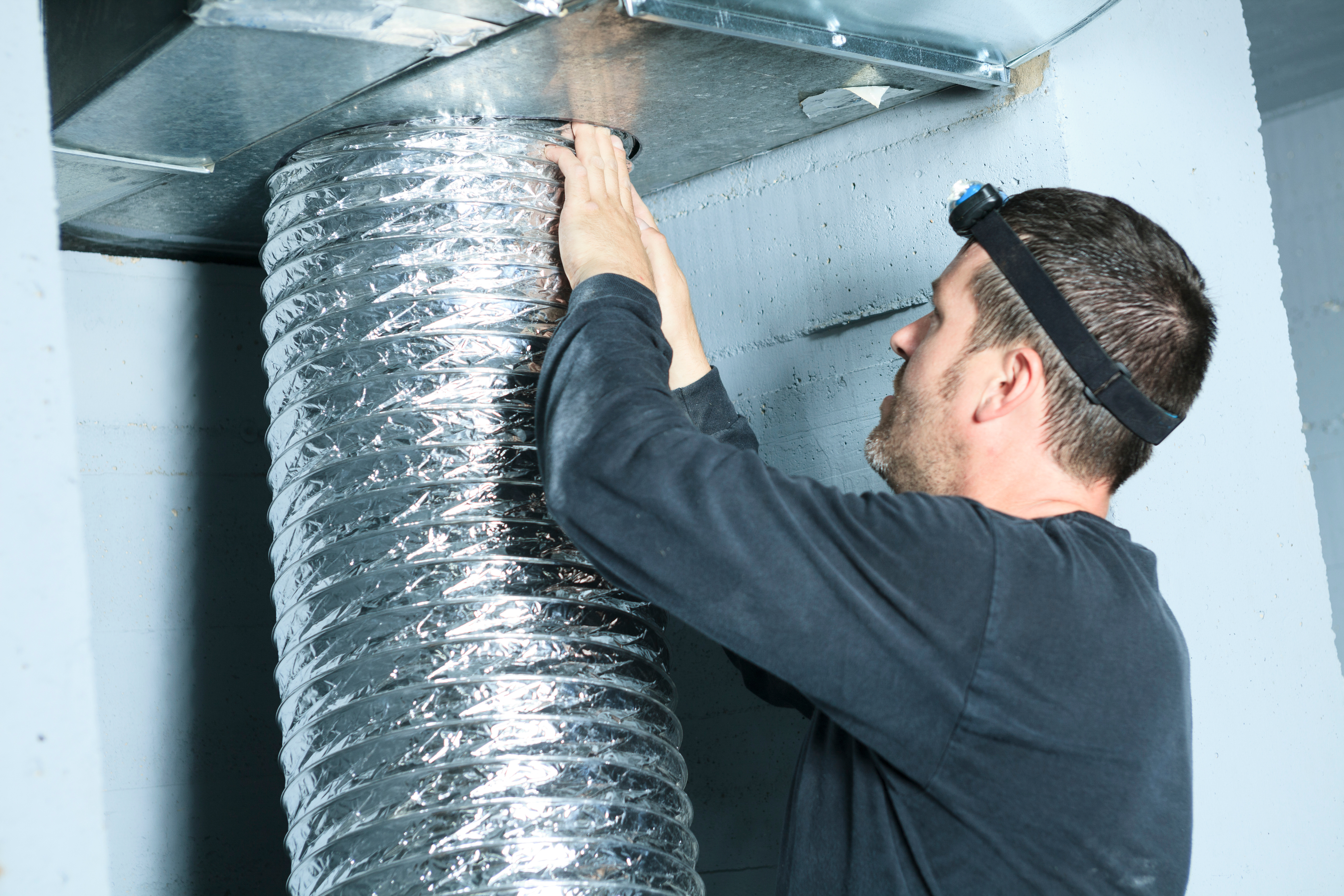 Technician cleaning dryer vent ductwork